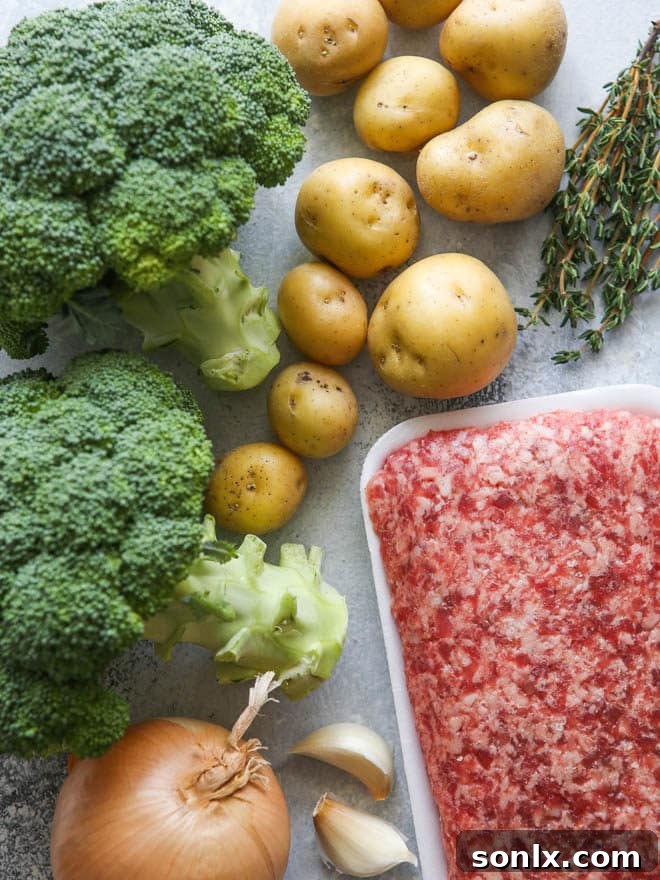 A vibrant flat lay of fresh ingredients laid out on a wooden board, including ground sausage, diced potatoes, chopped broccoli, onions, garlic, and fresh thyme, prepared for making a hearty soup.