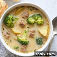A hearty bowl of Sausage Broccoli Potato Soup, garnished with fresh herbs.