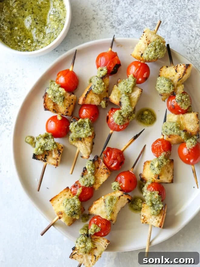 Close-up of freshly grilled bruschetta skewers adorned with a vibrant drizzle of green pesto, ready to be served as an appetizer.
