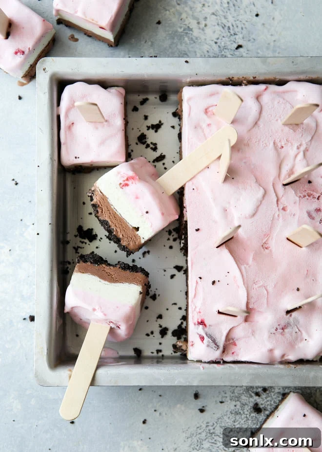 Delicious layers of chocolate, vanilla, and strawberry ice cream over an Oreo crust, ready to be enjoyed as Neapolitan Ice Cream Pops