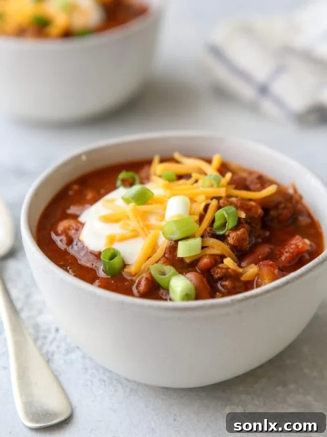 bowl of chili with toppings and a spoon