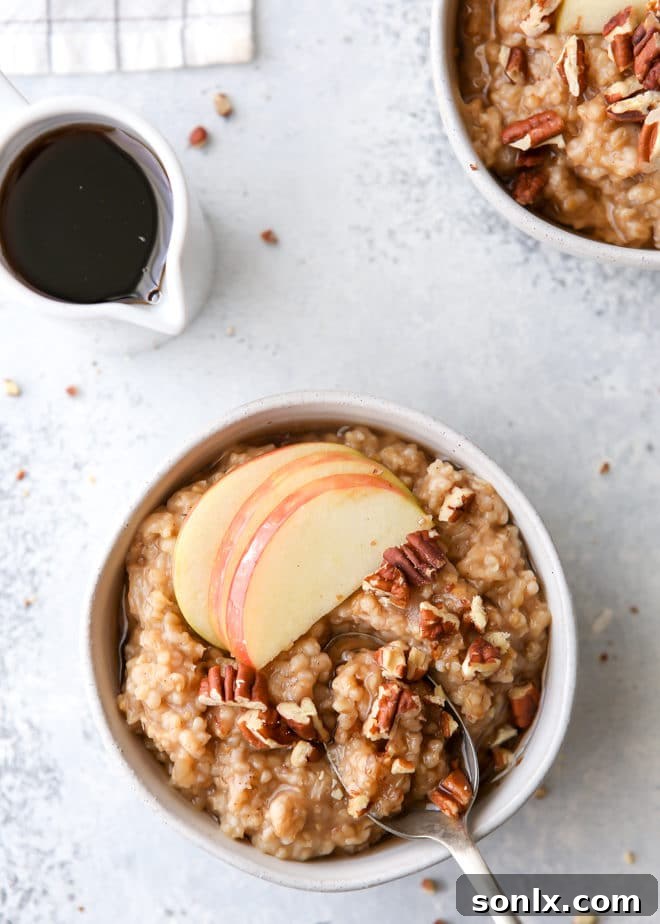Hearty Apple Cinnamon Oatmeal Bowls topped with pecans and maple syrup, ideal for a fall breakfast.