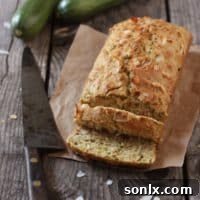 A beautifully golden-brown loaf of Toasted Coconut and Zucchini Bread, ready to be sliced and served.