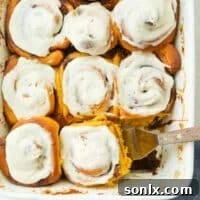 scooping pumpkin cinnamon rolls into a pan