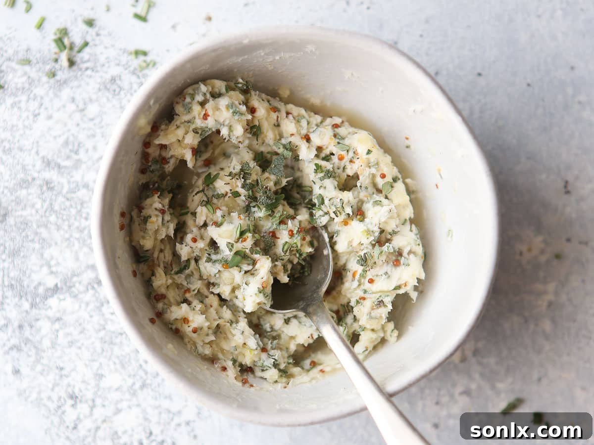 A small bowl of homemade herb compound butter, rich with fresh herbs, garlic, and lemon, ready to be spread on turkey.