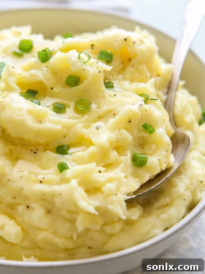 close up of mashed potatoes in bowl with scallions