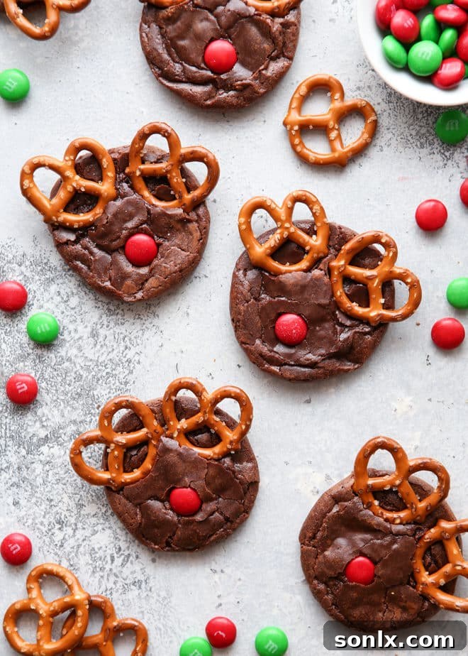 Close-up of a Rudolf brownie cookie, showcasing the fudgy texture, pretzel antlers, and red M&M nose.