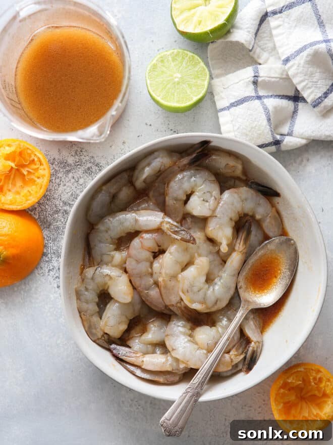 Raw shrimp marinating in a spicy-sweet citrus sauce, ready for cooking.