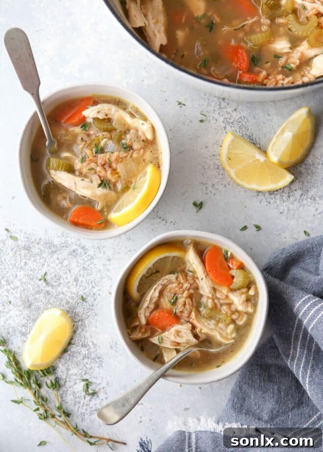 bowl of lemon chicken farro soup, garnished with fresh herbs