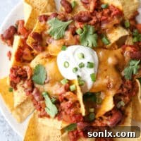Topped with quick and easy homemade chili, plenty of cheddar cheese and sour cream, these nachos are sure to be a big hit!