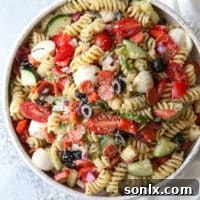 A close-up image of a vibrant Italian pasta salad with fresh ingredients.