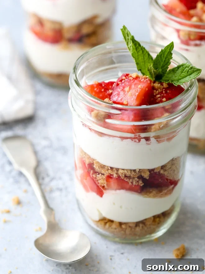 Delightful layers of fresh strawberries, creamy yogurt whipped cream, and crispy graham cracker crumble form these irresistible parfaits, perfect for a refreshing summer treat.