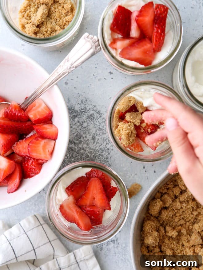 A stunning side view of Strawberry Yogurt Parfaits stacked in clear glasses, showcasing the vibrant layers and appealing texture of the components.