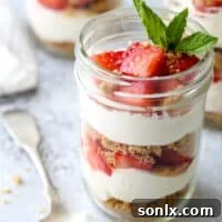 Layers of fresh strawberries, yogurt whipped cream, and graham cracker crumble make up these adorable and irresistible parfaits.