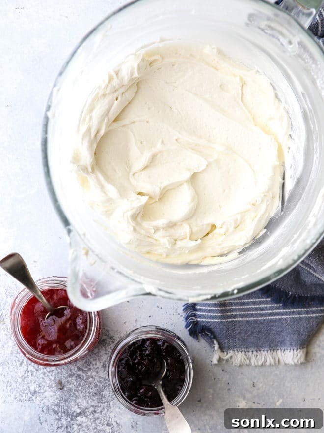Vanilla buttercream frosting about to be swirled with berry preserves