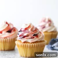Delicate vanilla cupcakes topped with buttercream frosting swirled with berry preserves are lovely and delicious!