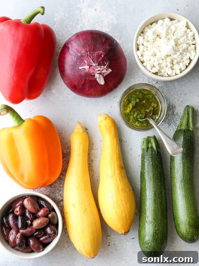 All the fresh ingredients needed for a delicious and colorful grilled vegetable antipasto platter, including an assortment of seasonal vegetables, Kalamata olives, and goat cheese.