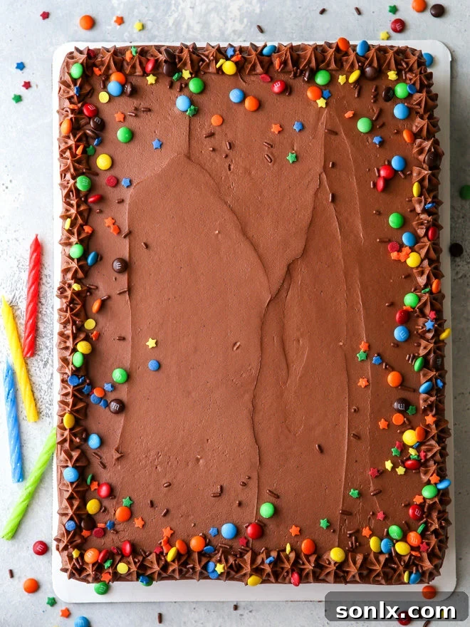 A slice of incredibly moist one-bowl chocolate sheet cake with easy fudge frosting, ready to be enjoyed by chocolate lovers.