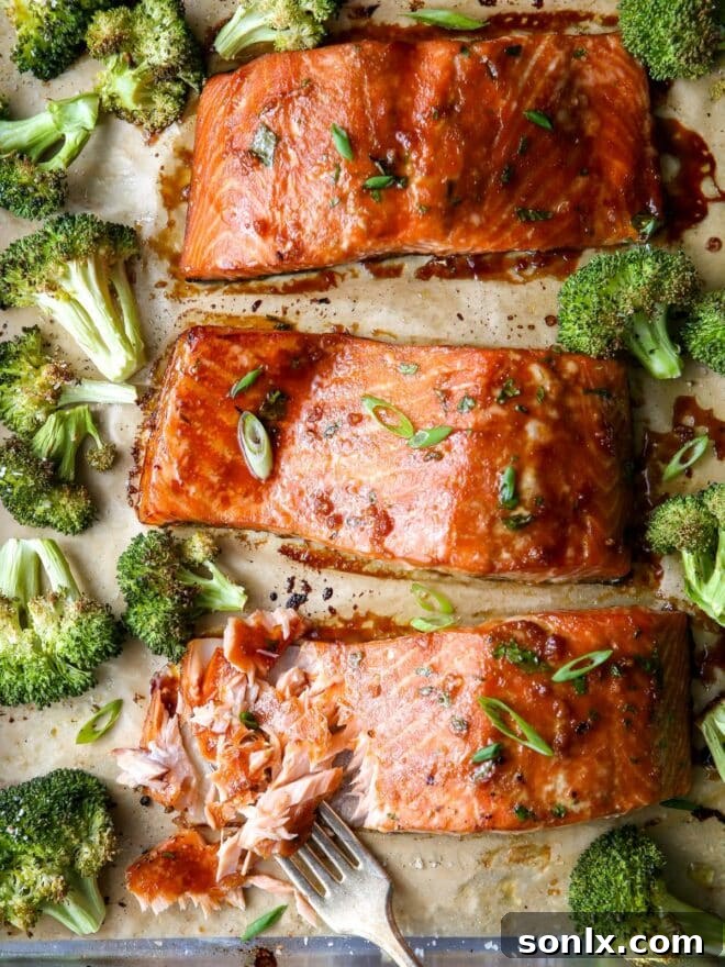 close up of flaky salmon with roasted broccoli and scallion garnish