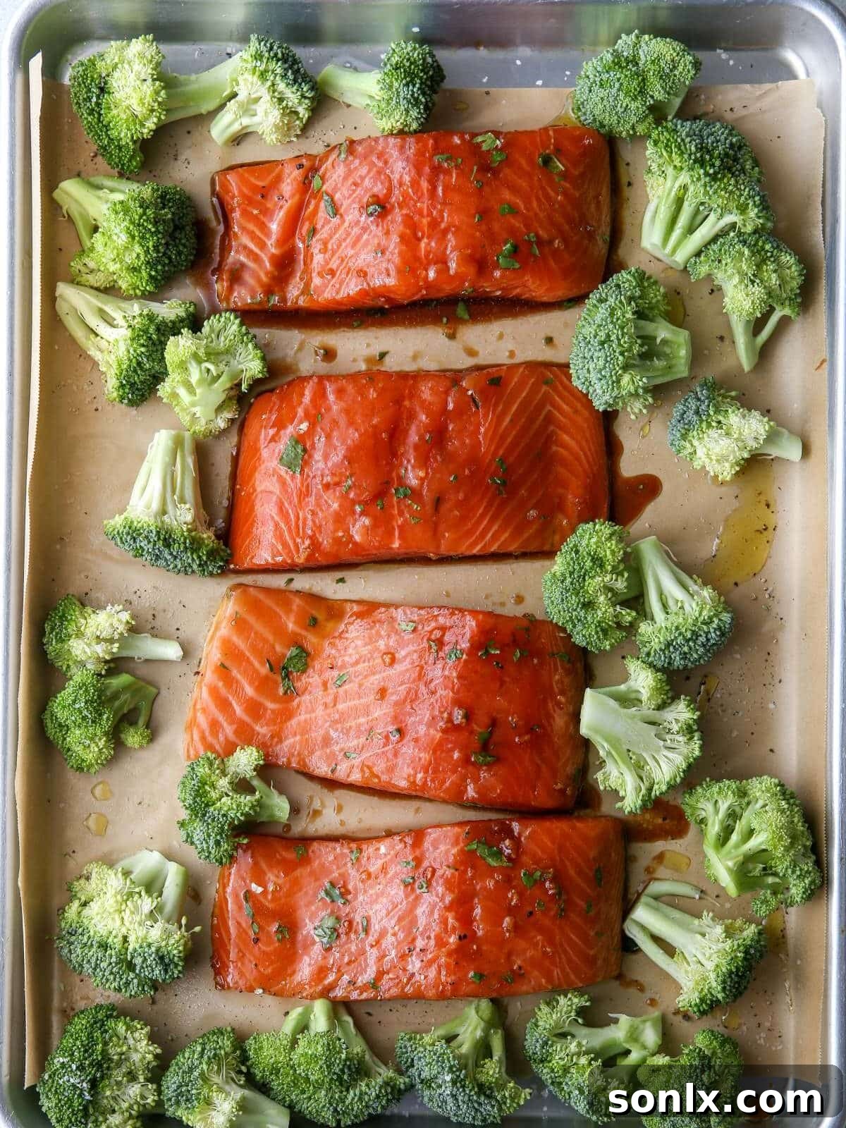sheet pan with salmon and broccoli arranged for roasting