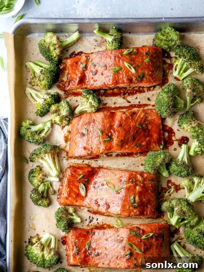 roasted Asian-glazed salmon and broccoli on a sheet pan, garnished with scallions