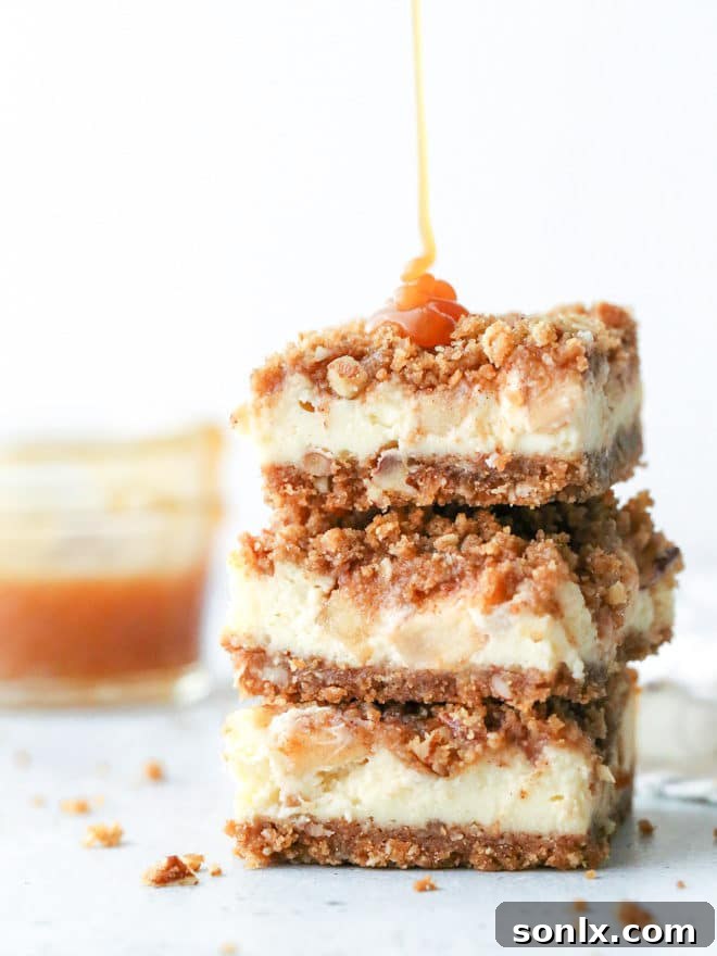 Rich and creamy caramel apple cheesecake bars with layers of graham cracker streusel, cream cheese, cinnamon apples, and caramel drizzle