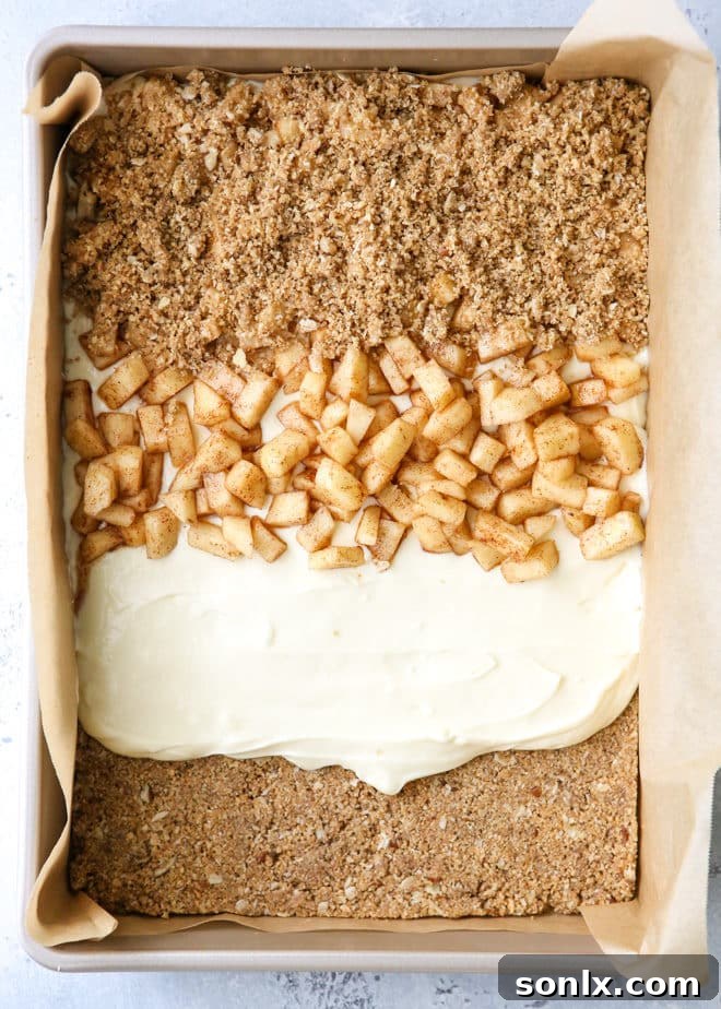 Layers of graham cracker streusel, smooth cream cheese filling, cinnamon apple chunks, and caramel drizzle combine to form these rich and creamy caramel apple cheesecake bars.
