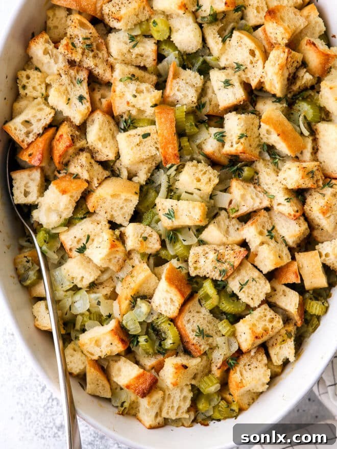 A serving of classic stuffing on a plate, garnished with fresh herbs, ready to be enjoyed.