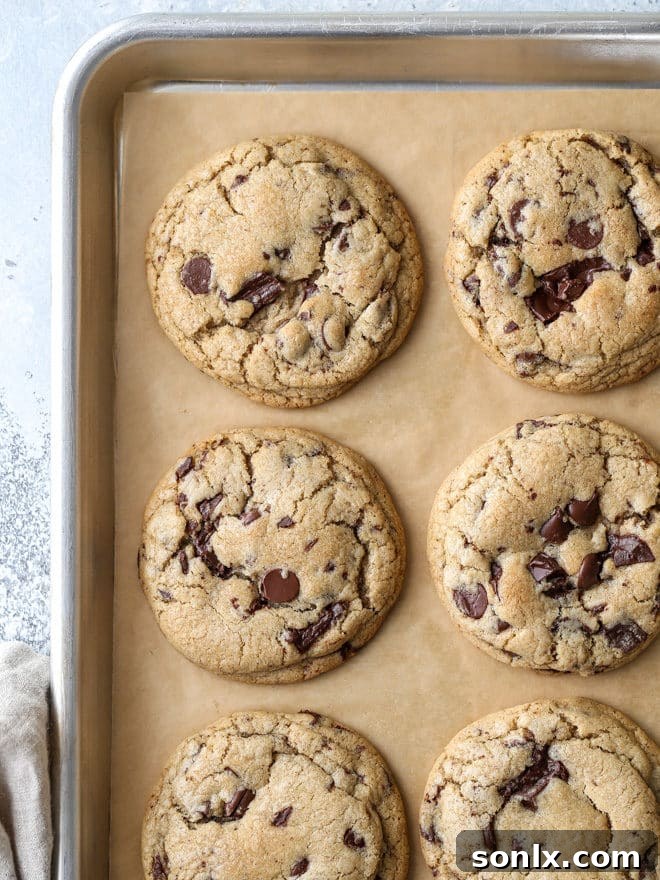 A stack of freshly baked, thick and chewy chai spice chocolate chip cookies with melted dark chocolate and warm spices.