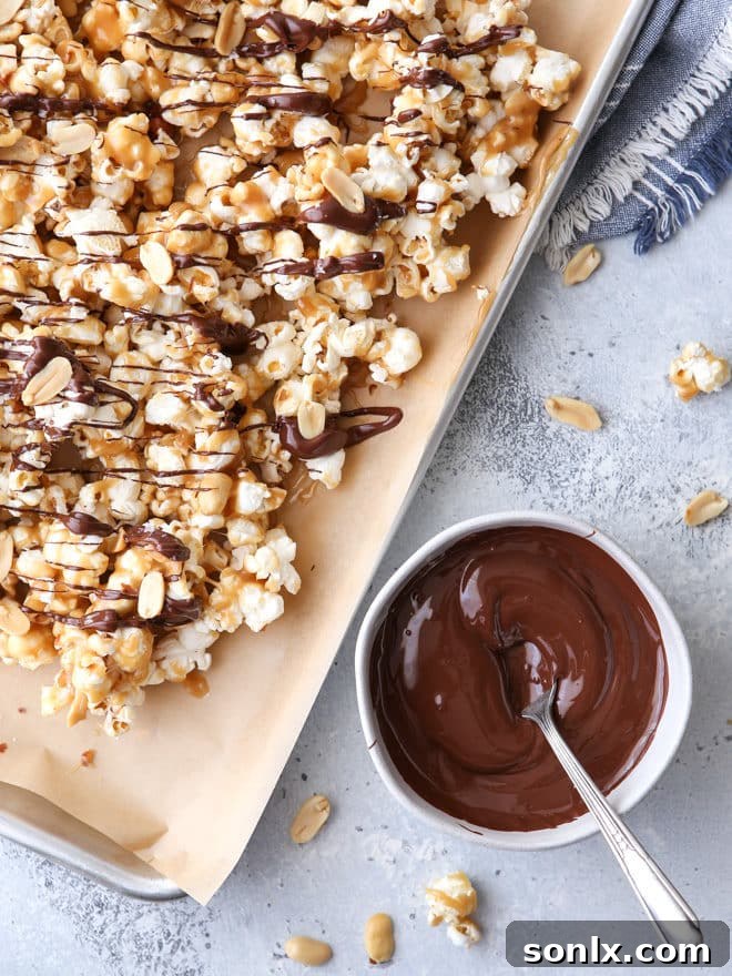 A close-up of a pile of finished chocolate caramel corn, showing the dark chocolate drizzle and flaky salt.