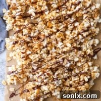 Chocolate Caramel Corn in a bowl, with a smaller bowl of flaky salt nearby.