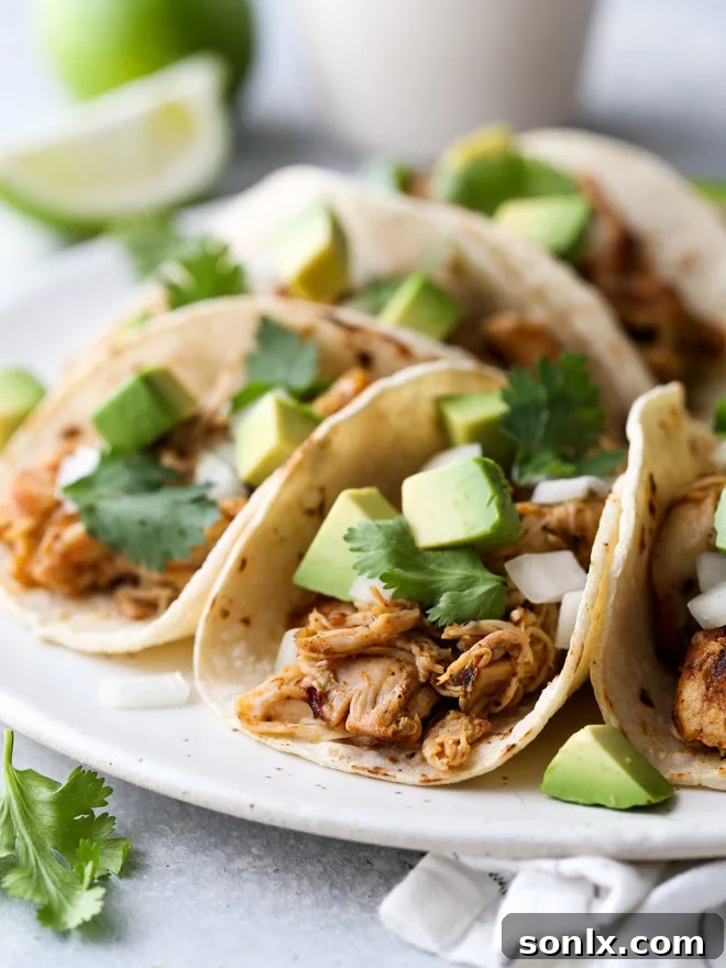 These easy Mexican street tacos filled with spiced shredded chicken, chopped onions, avocado, and cilantro are sure to become a favorite with everyone!