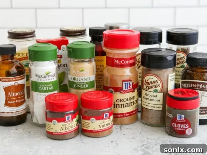Various baking spices neatly arranged in glass containers on a kitchen shelf