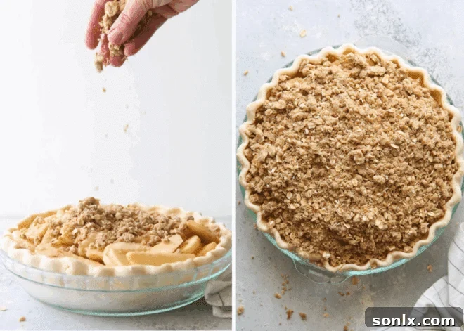 Close-up of hands assembling an apple crumble pie, carefully layering apples and topping into a crust in a pie dish.