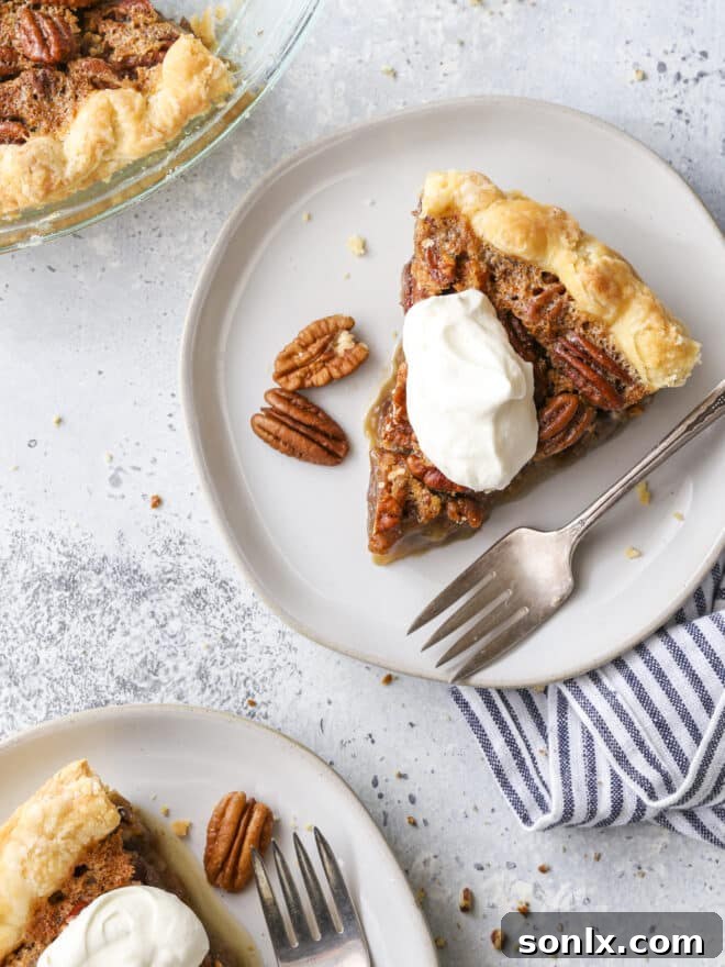 Four slices of classic pecan pie on white plates, each topped with a generous dollop of whipped cream, ready to be served for a festive holiday dessert.
