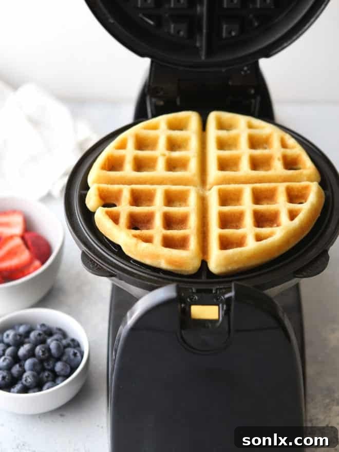 A close-up view of a single buttermilk waffle segment, showcasing its crispy texture and airy interior.