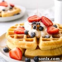 stack of buttermilk waffles with drizzle of syrup