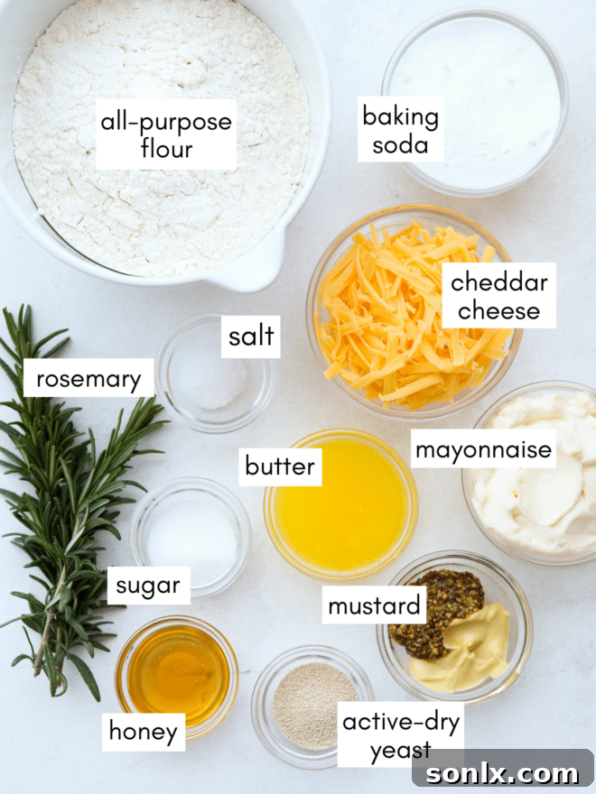 Various ingredients for pretzel bites laid out: flour, yeast, salt, sugar, rosemary, cheddar cheese, butter, and mustard.