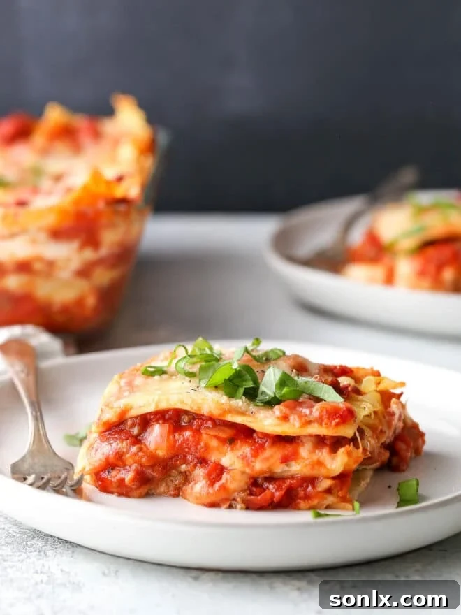 Classic homemade lasagna serving on a plate, showcasing its rich layers of pasta, meat sauce, and cheese.