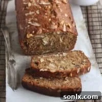 Close-up of a slice of coconut banana bread with walnuts