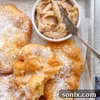 A perfectly fried piece of fry bread, invitingly slathered with creamy cinnamon honey butter.