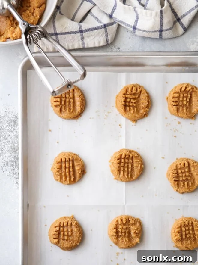 Portioning out perfectly round dough balls for flourless peanut butter cookies before baking.