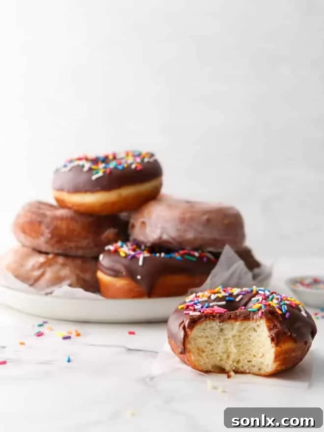 a yeast-raised doughnut with a bite taken out, revealing its fluffy interior and sweet topping