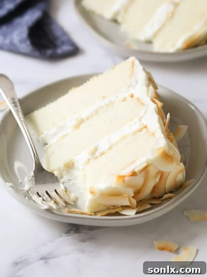 A close-up of a slice of southern coconut cake, showing its light, fluffy texture and inviting appearance, ready to be enjoyed.