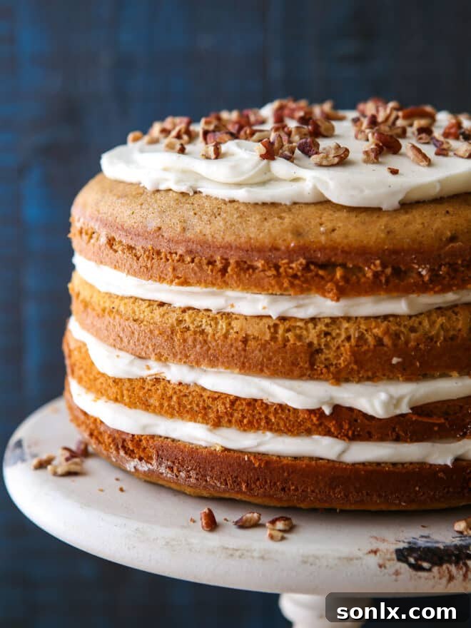 Sweet Potato Spice Cake layers being frosted with creamy vanilla bean cream cheese frosting.