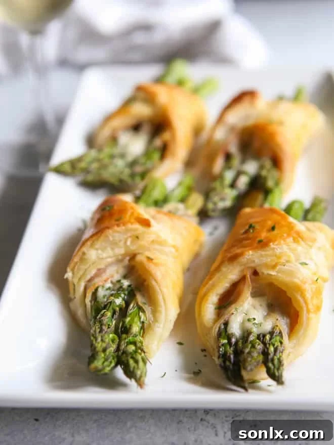 Baked golden brown asparagus and pancetta puff pastry bundles ready to serve.