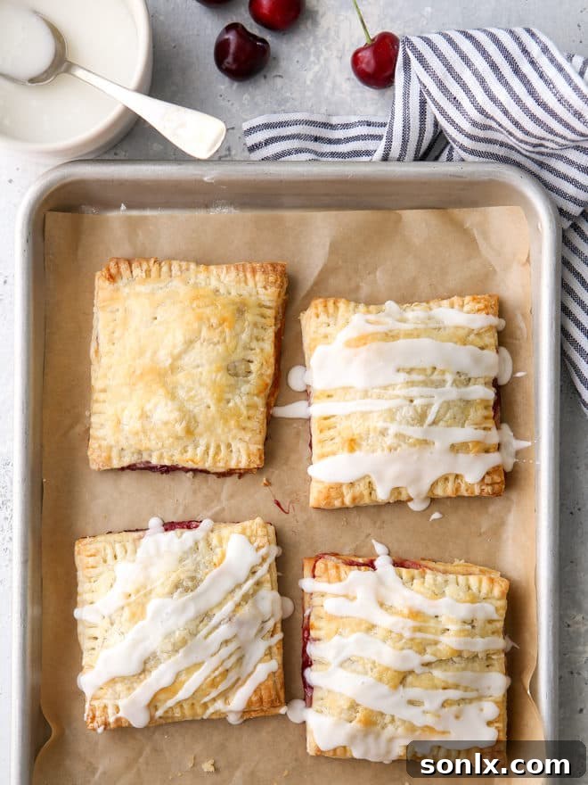 Drizzling sweet almond icing over freshly baked cherry hand pies