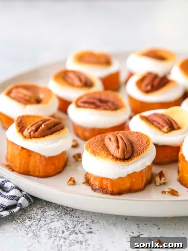 Sweet potato bites on a serving platter, topped with toasted marshmallows and pecans.