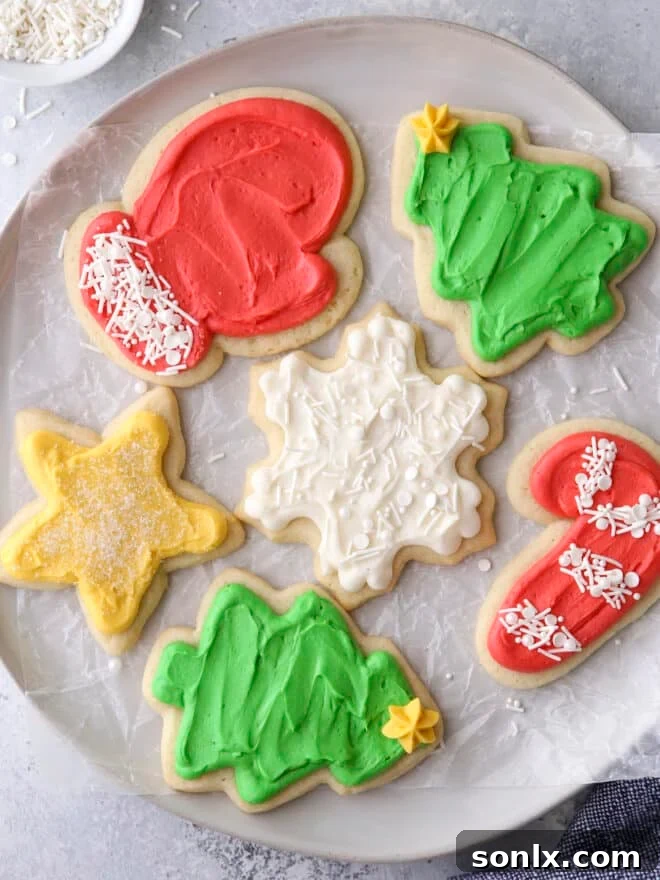 A delightful closeup of expertly frosted sugar cookie cut-outs on a plate, adorned with colorful sprinkles, highlighting their festive appeal.