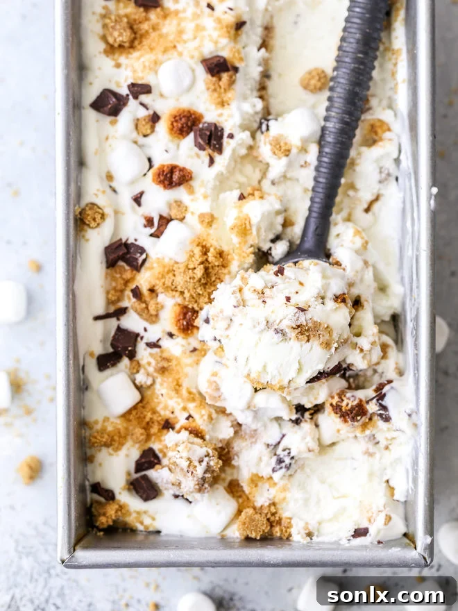Scoops of no-churn s'mores ice cream with visible graham cracker crumble, chocolate chunks, and toasted marshmallows.